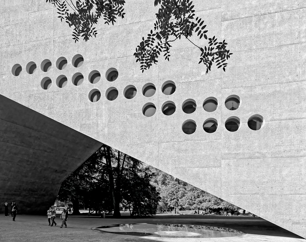 grayscale photo of people walking on sidewalk near trees