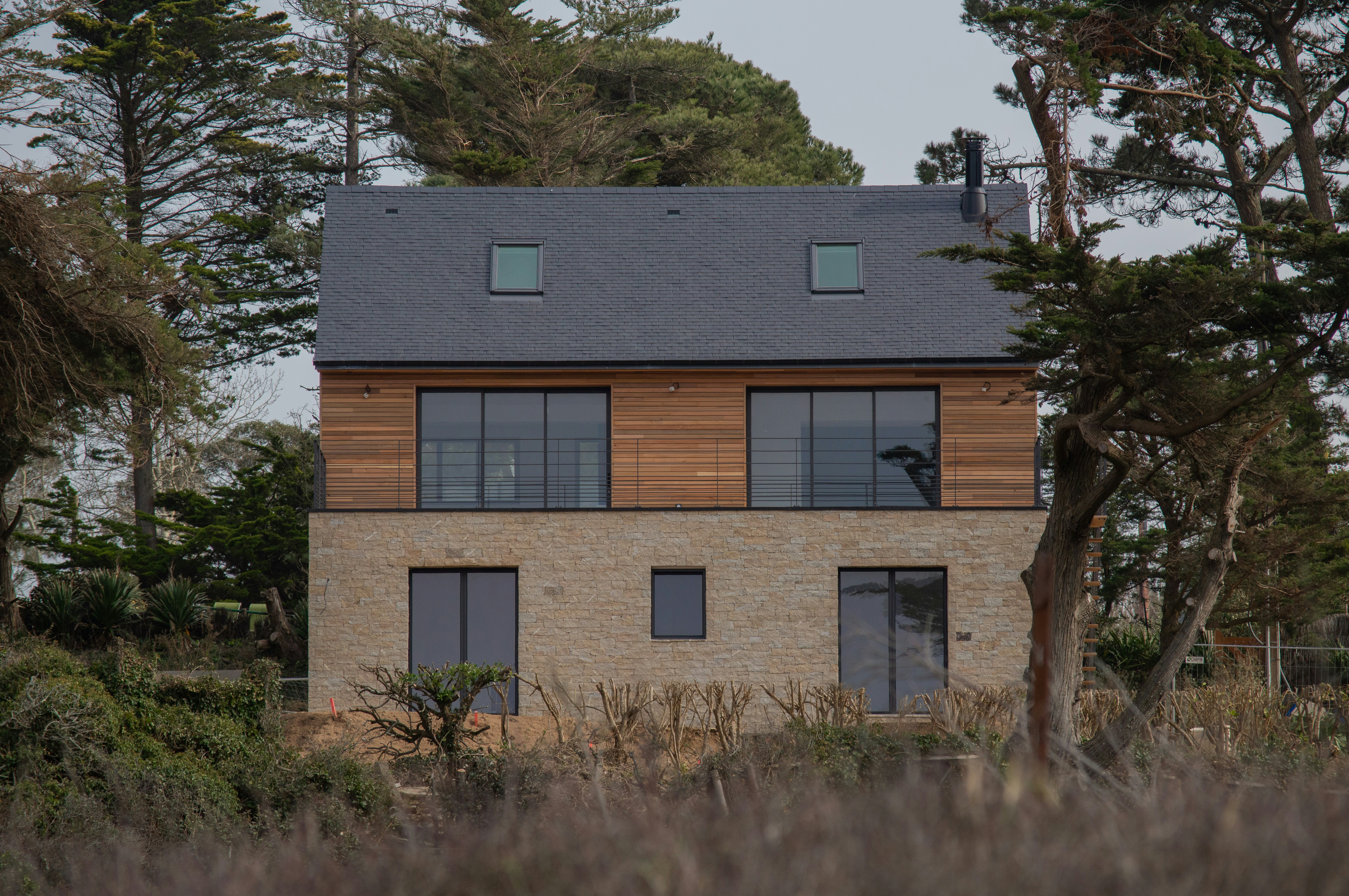 Brown and white concrete house near green trees during daytime photo ...