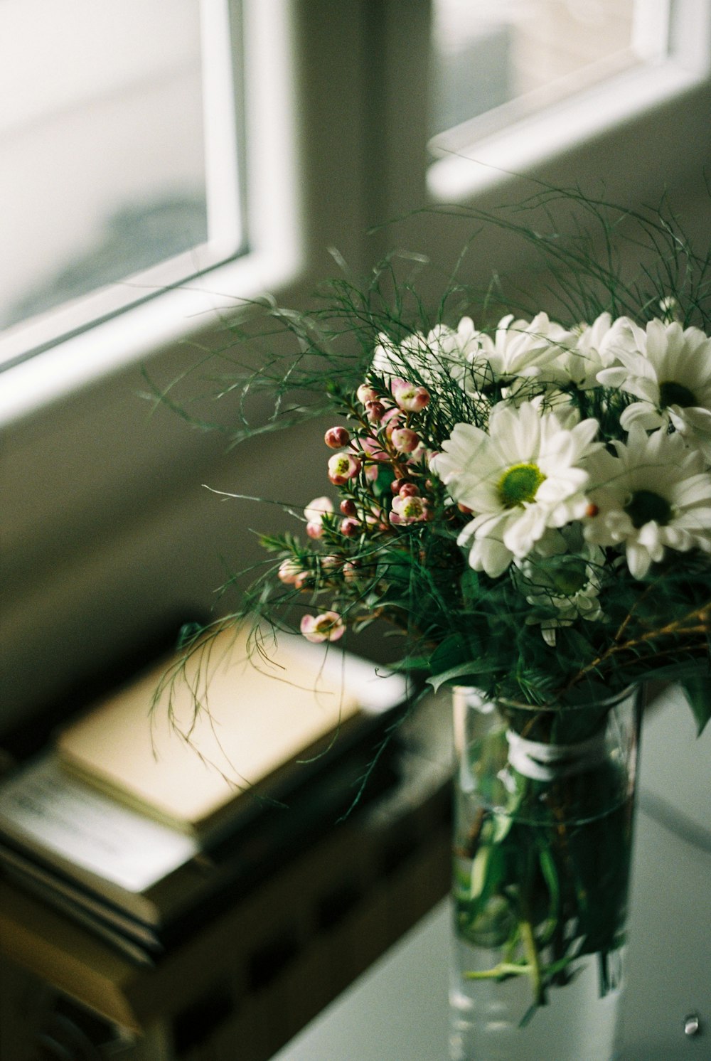 white and red flowers on clear glass vase