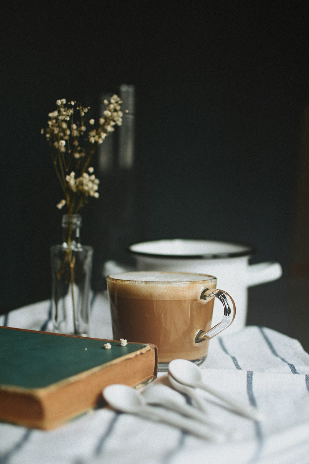 white ceramic mug on white table cloth