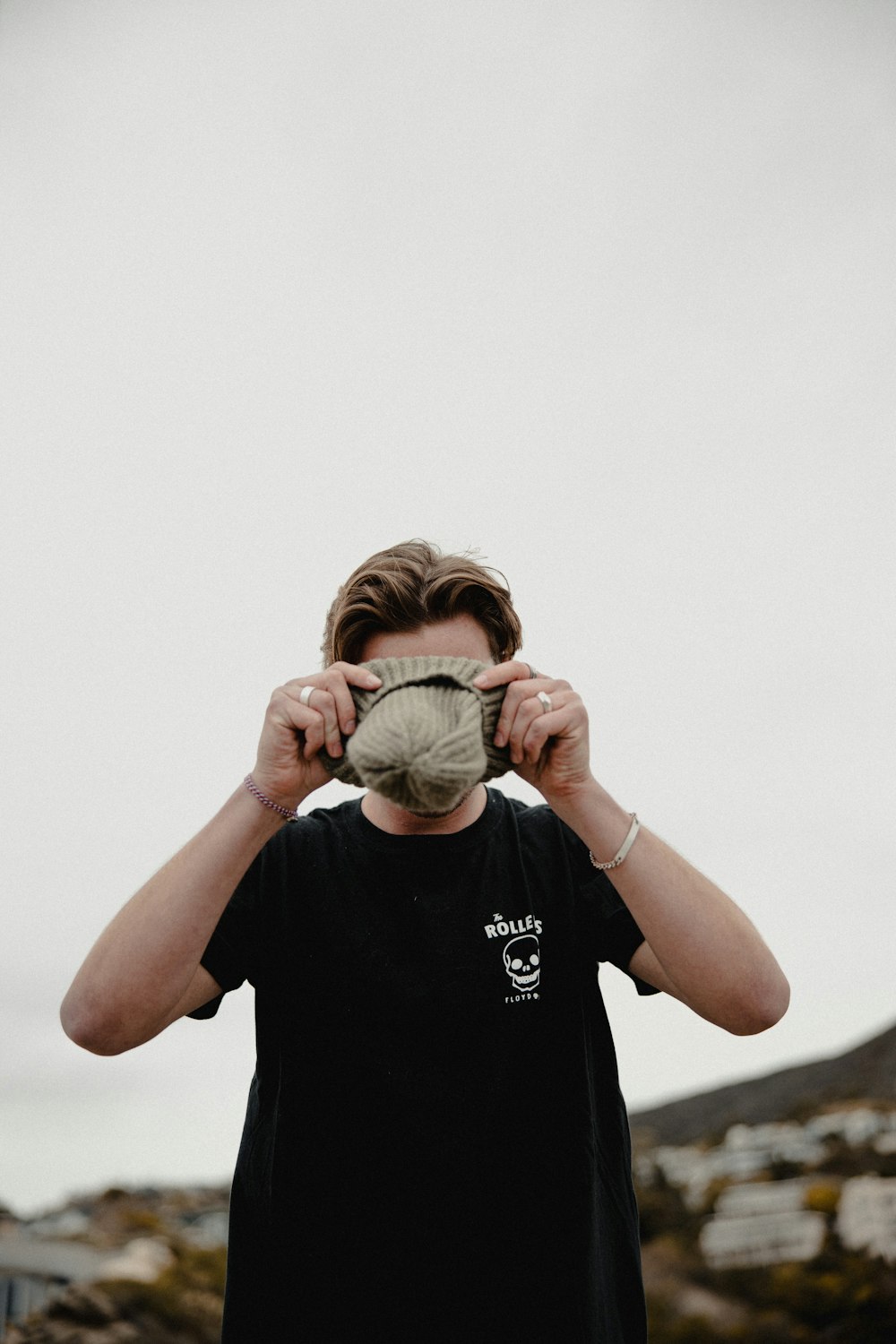 man in black crew neck t-shirt covering his face with green and white textile