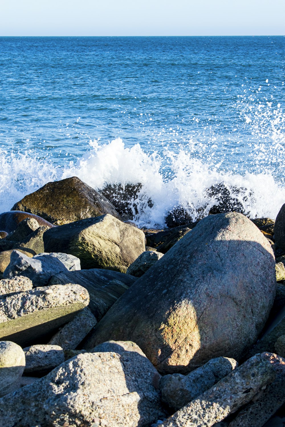 Rocas grises y marrones cerca del cuerpo de agua durante el día