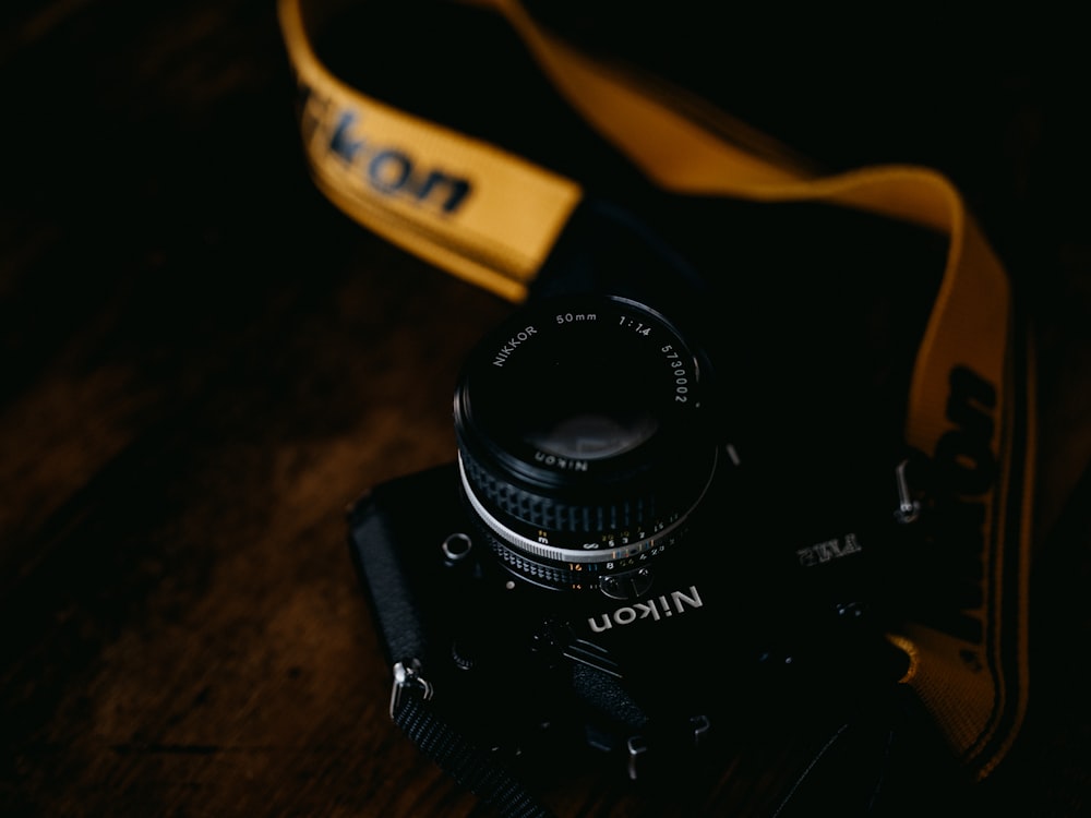 black nikon camera on brown wooden table