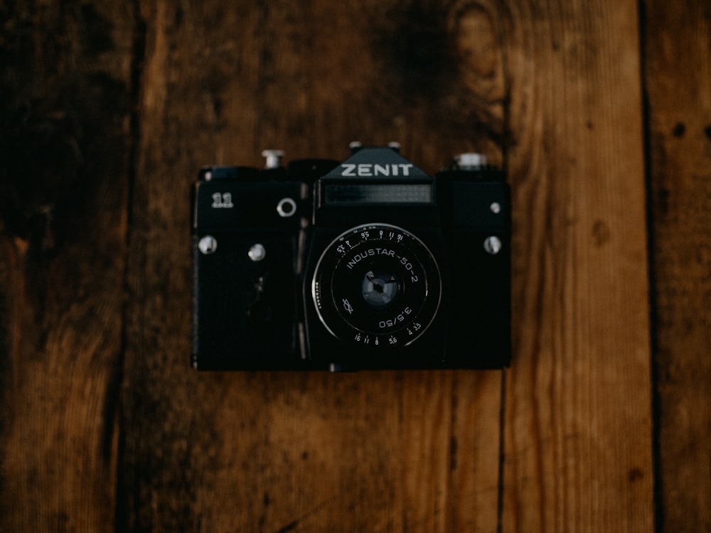 black nikon dslr camera on brown wooden table