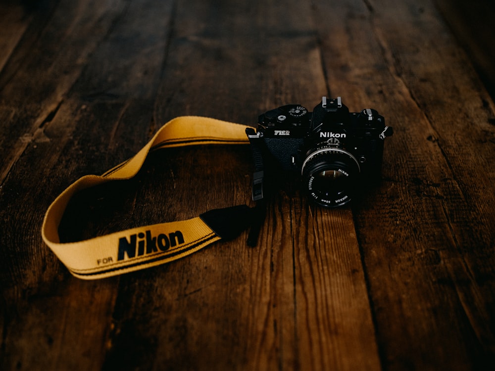 black nikon dslr camera on brown wooden table