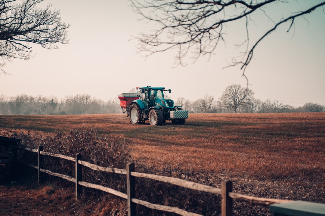 green tractor on brown field during daytime