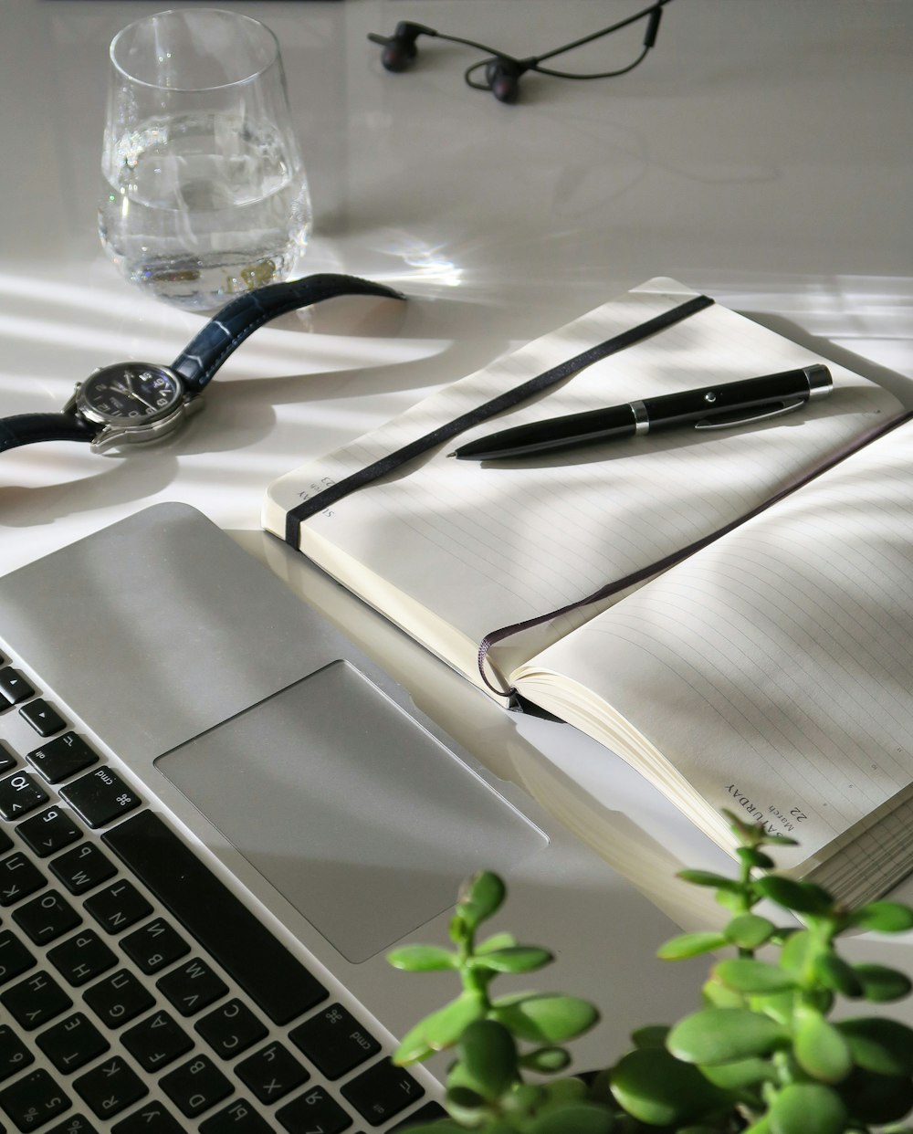 Stylo noir sur papier blanc à côté du MacBook Pro
