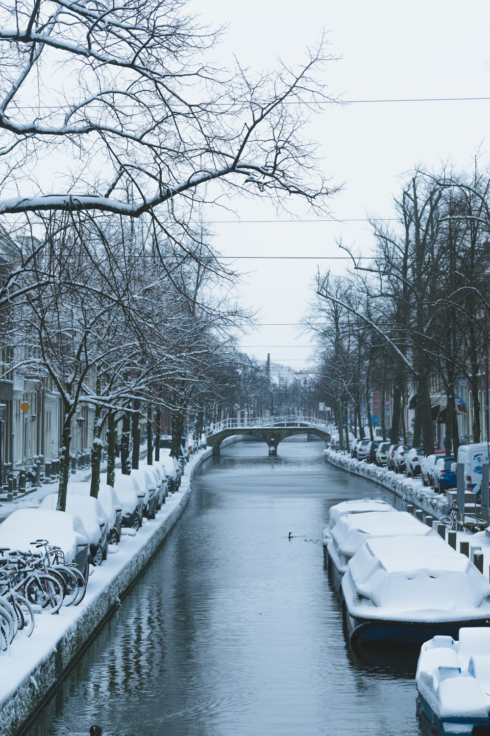 Schneebedeckte Straße mit seitlich geparkten Autos