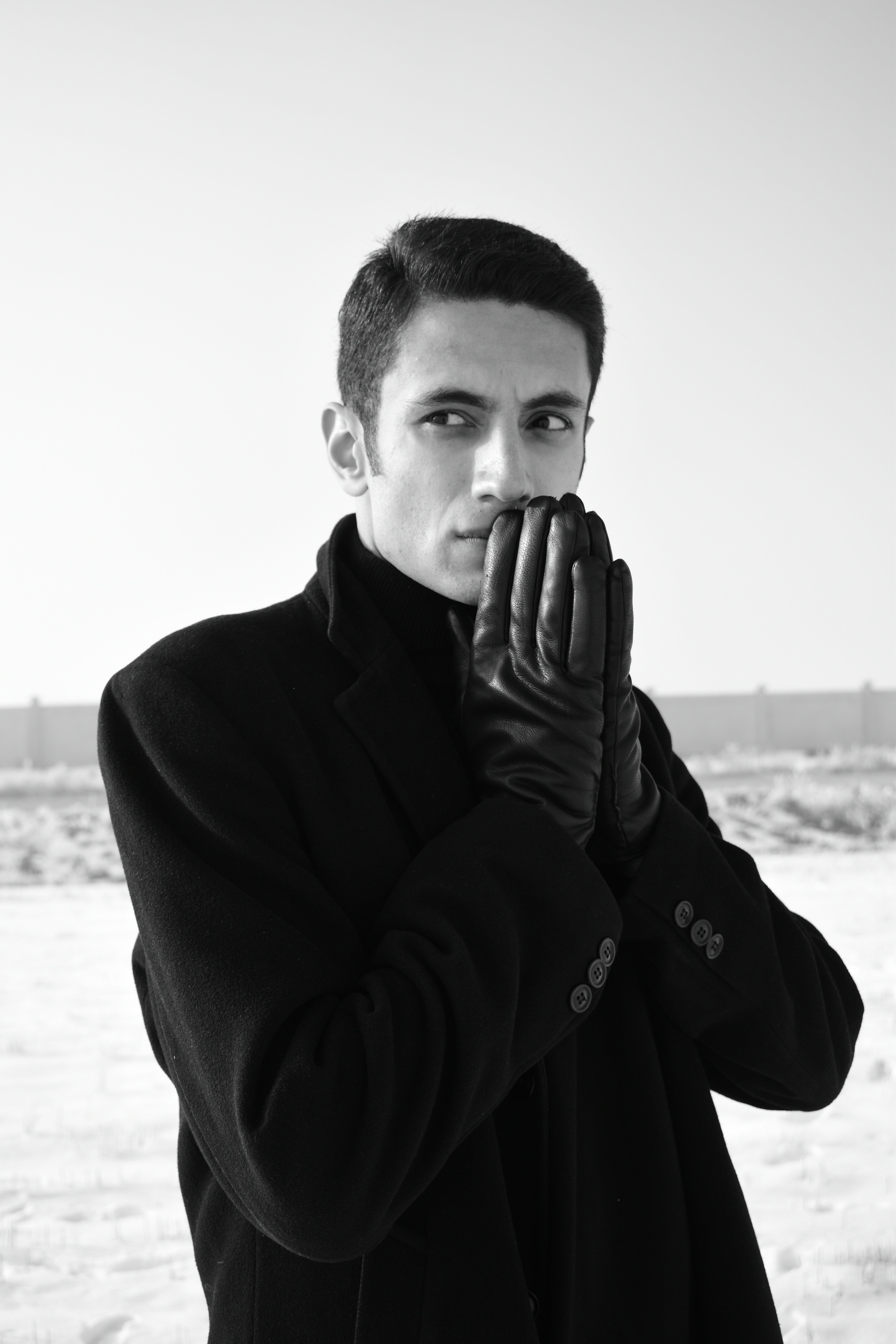 man in black long sleeve shirt covering his face with his hand
