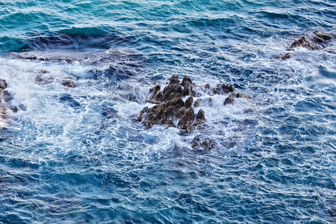 ocean waves crashing on rocks during daytime