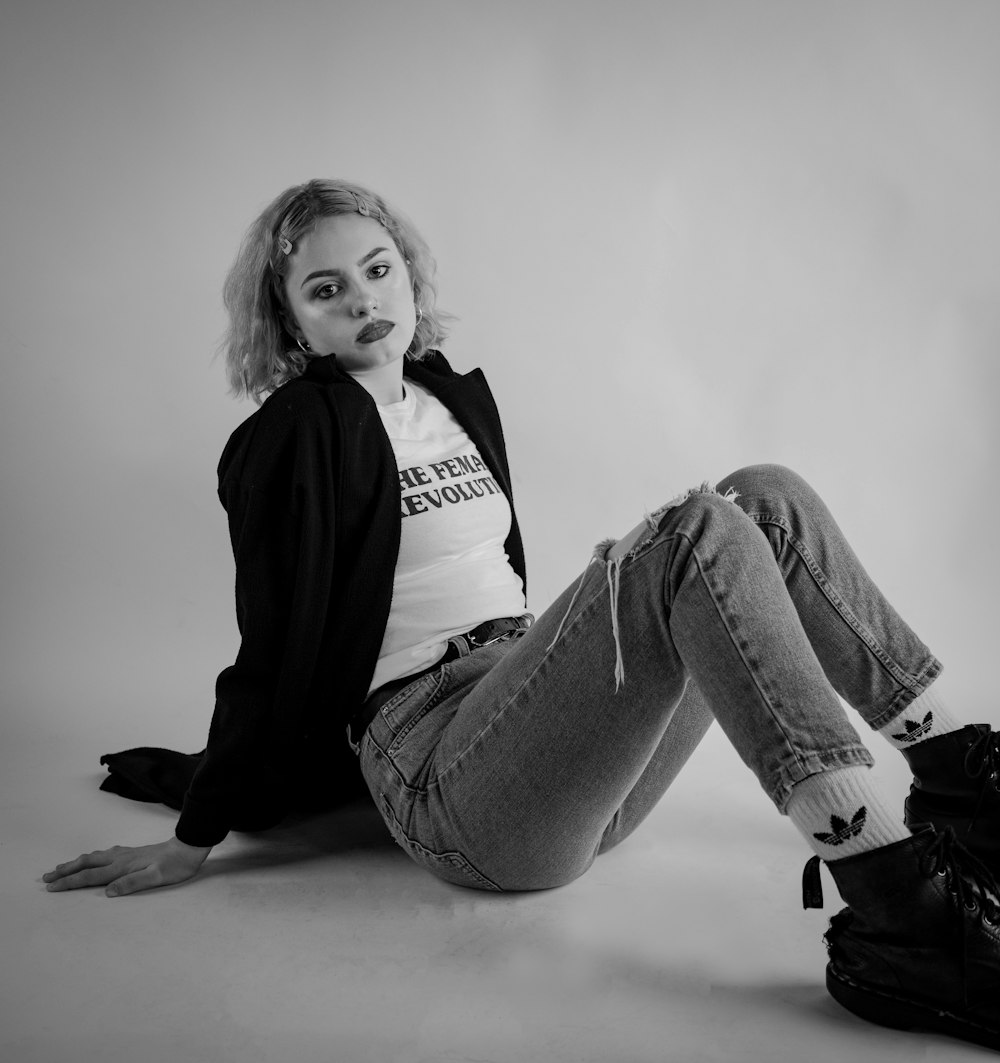 woman in black long sleeve shirt and gray denim jeans sitting on floor