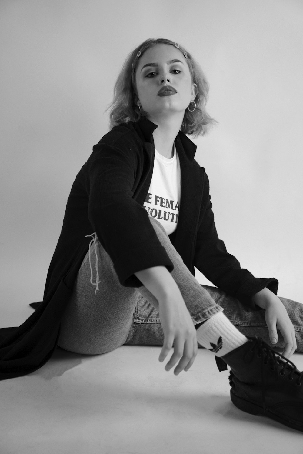 a black and white photo of a woman sitting on the floor