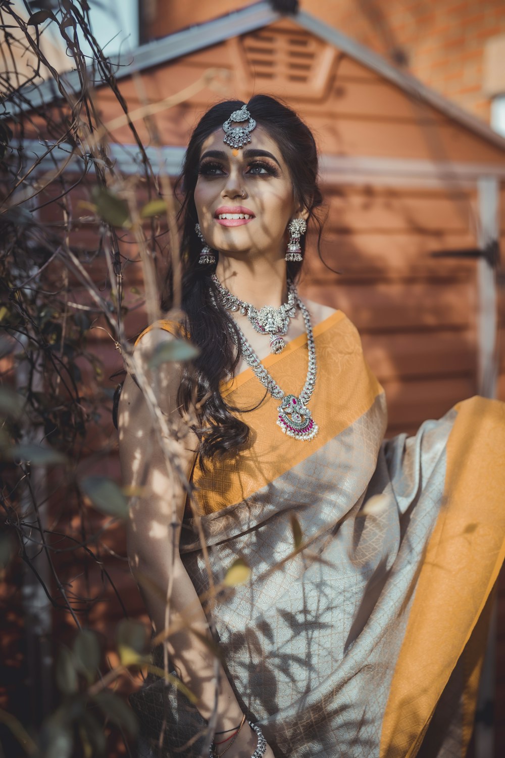 woman in yellow and white floral long sleeve shirt standing and smiling