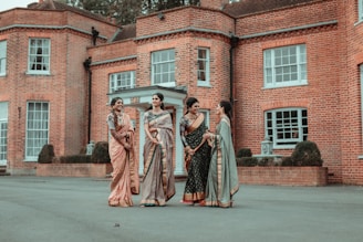 3 women in brown dress standing on gray concrete floor during daytime