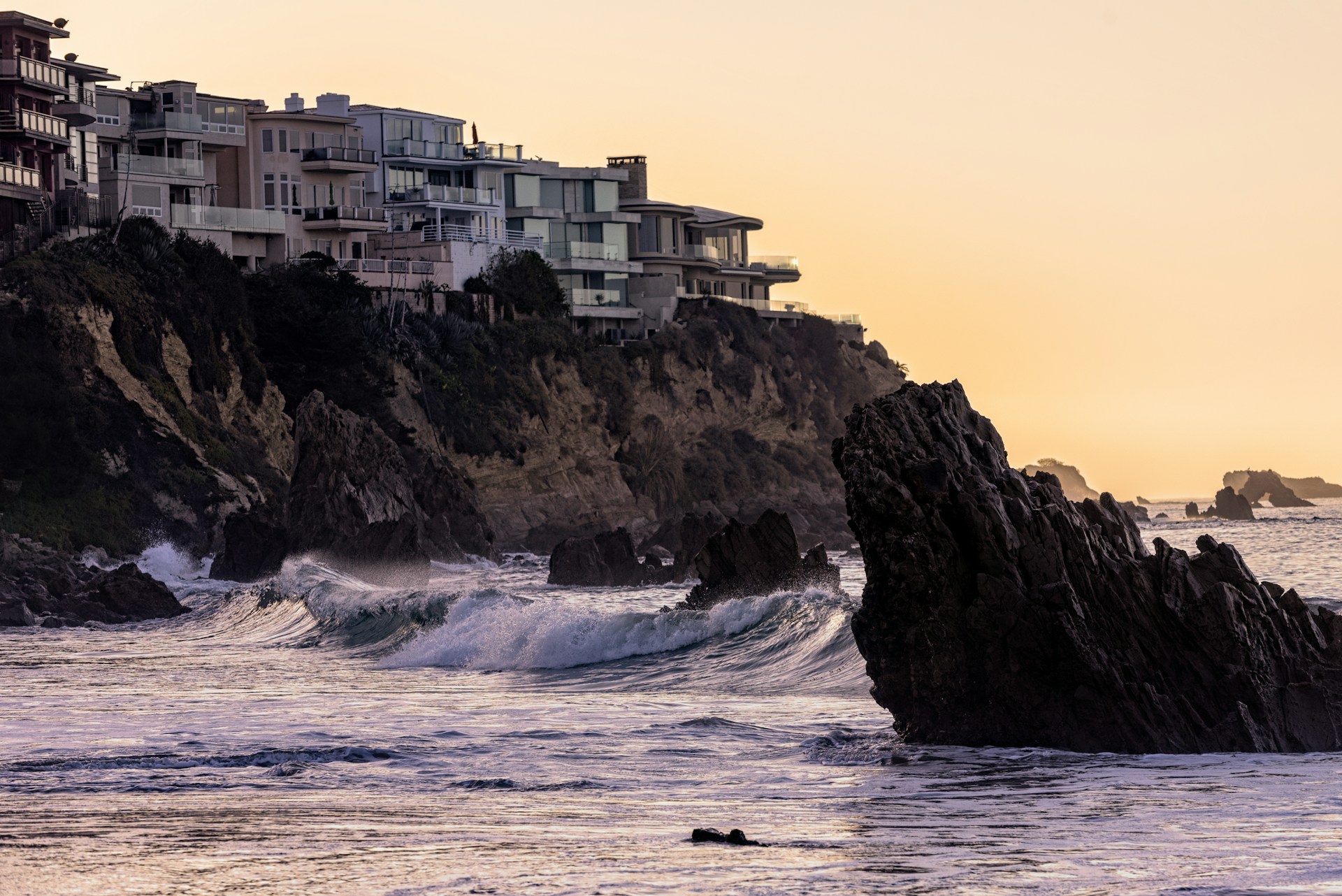 white concrete building on cliff by the sea