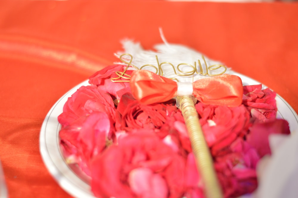 pink rose on red round plate