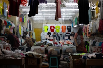 woman in white and black dress standing near red and white window curtain
