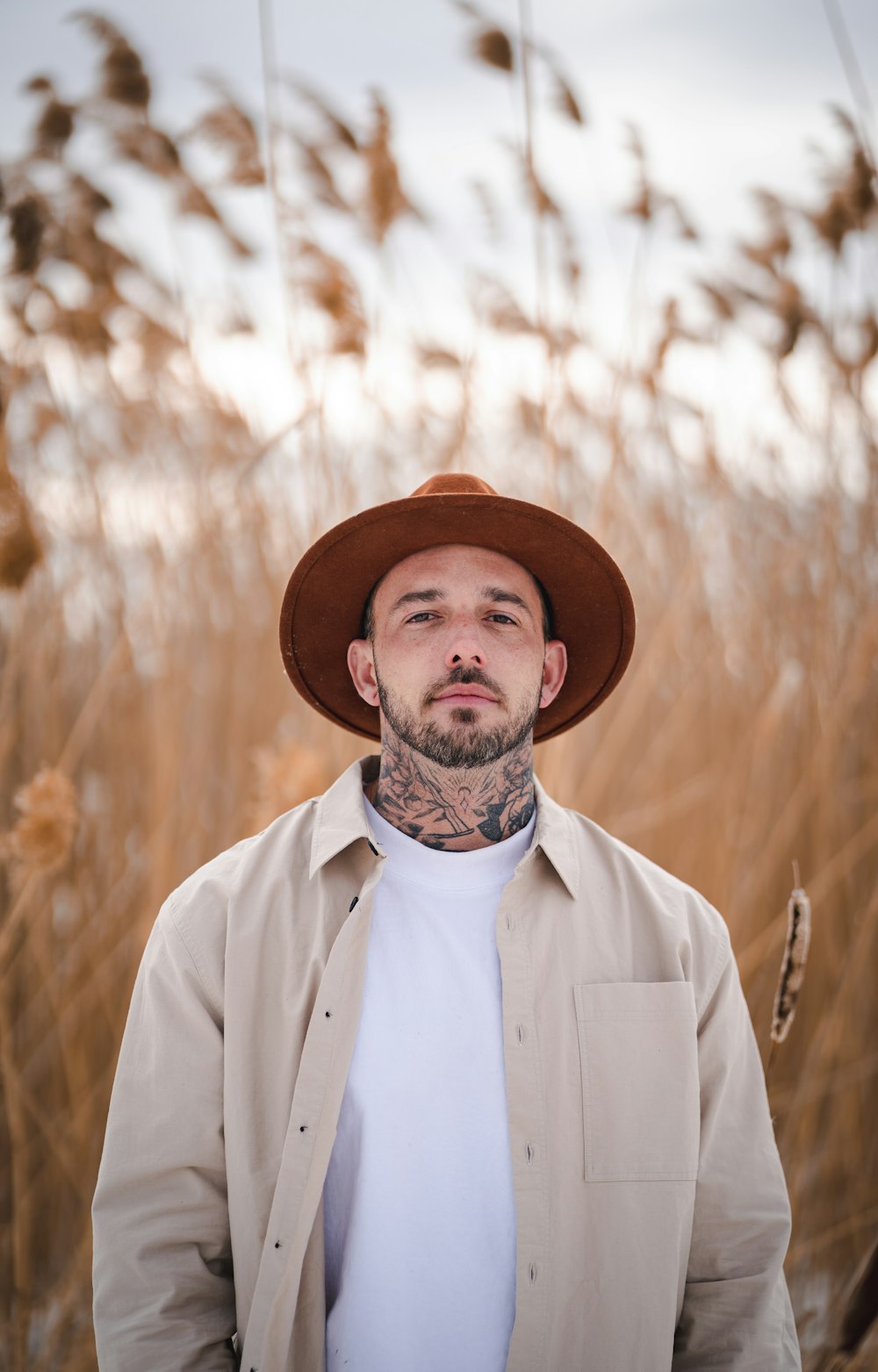 man in white button up shirt wearing brown hat