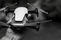 A close-up of hands assembling a sleek drone with black and orange accents.