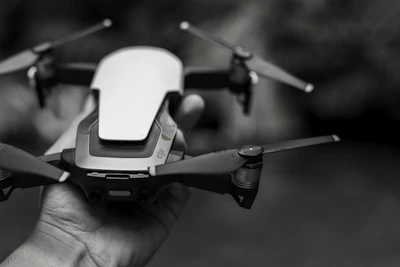 A close-up of hands assembling a sleek drone with black and orange accents.
