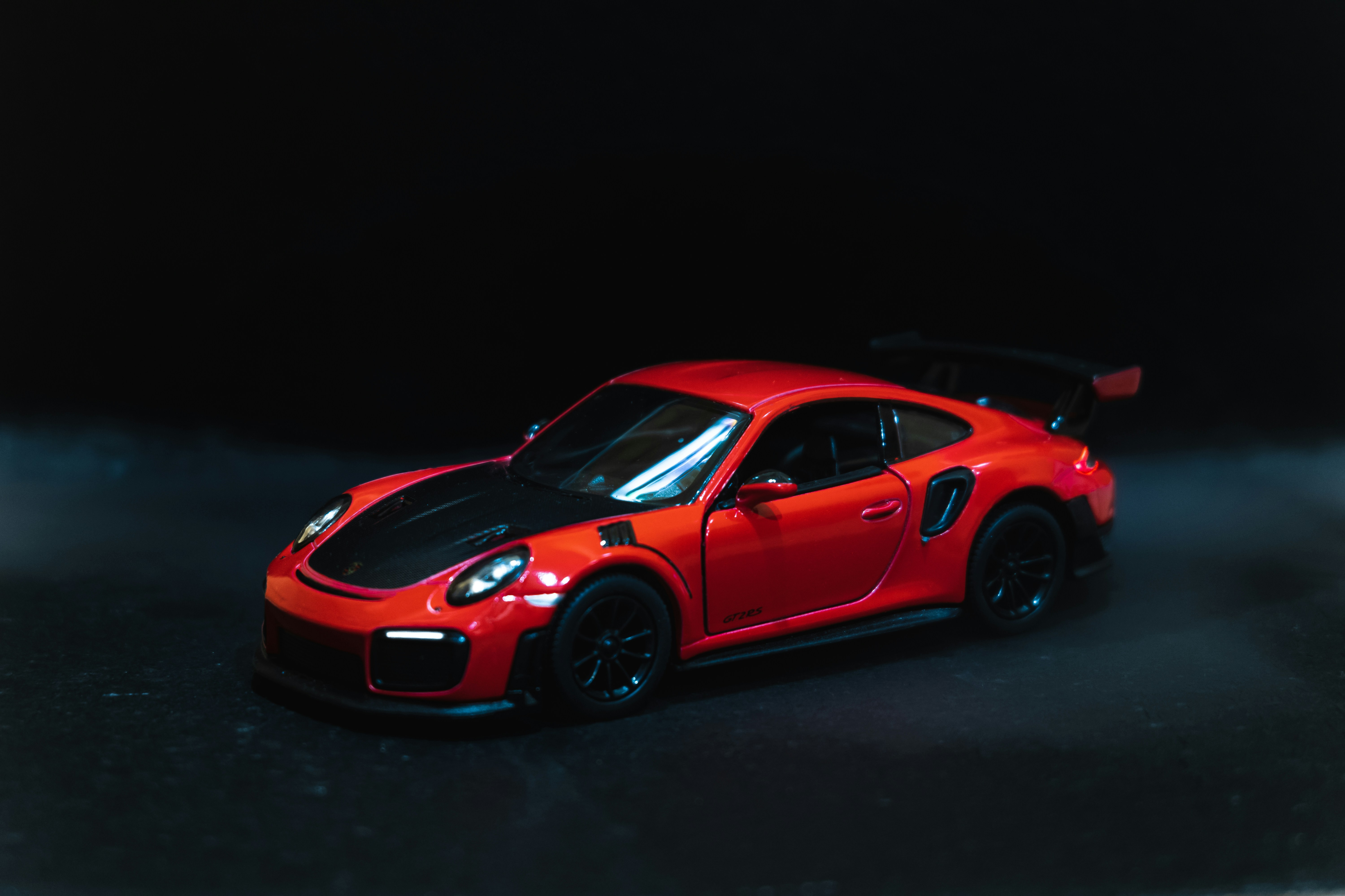Red sports car die-cast model on dark surface