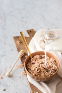 Fresh grains and pellets arranged in a wooden bowl.