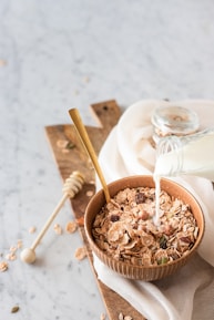 Fresh goat milk poured into a glass bowl surrounded by natural ingredients.