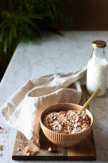 A cozy kitchen scene with a bowl of homemade granola and fresh fruit on a rustic wooden table bathed in warm morning light.