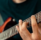 person playing guitar in close up photography