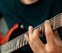 person playing guitar in close up photography
