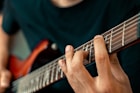person playing guitar in close up photography