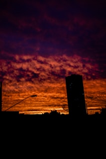 Dramatic photo of Brasília’s iconic architecture under a smoky, fiery sky at sunset.