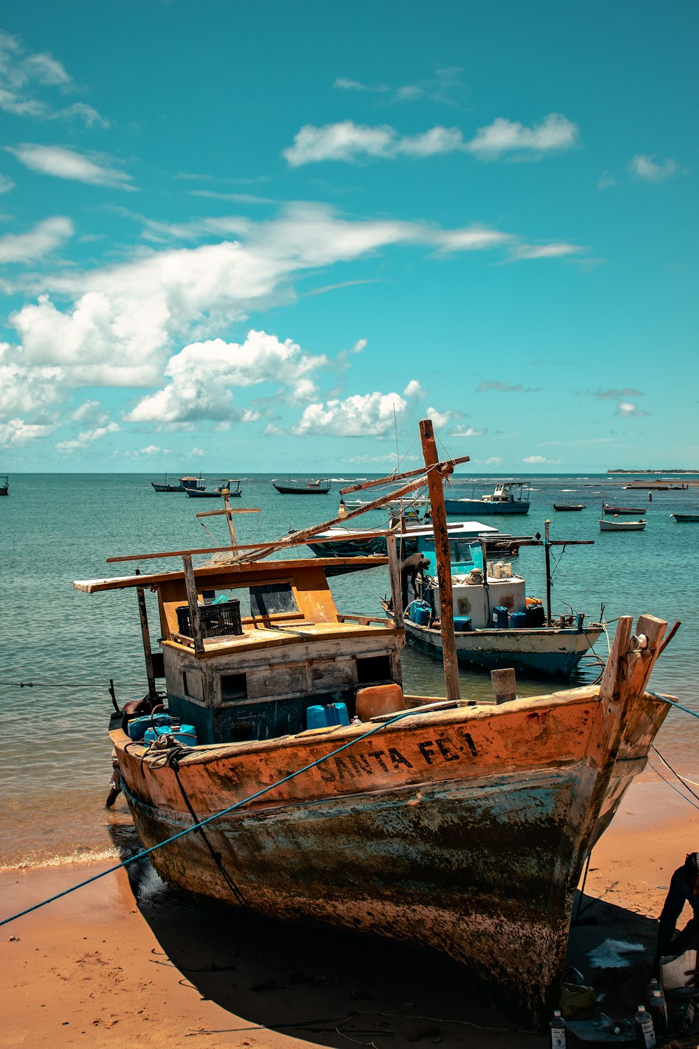 Barco marrón y azul en la playa durante el día