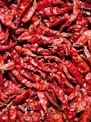 Close-up of vibrant dried chili peppers in wooden crates.