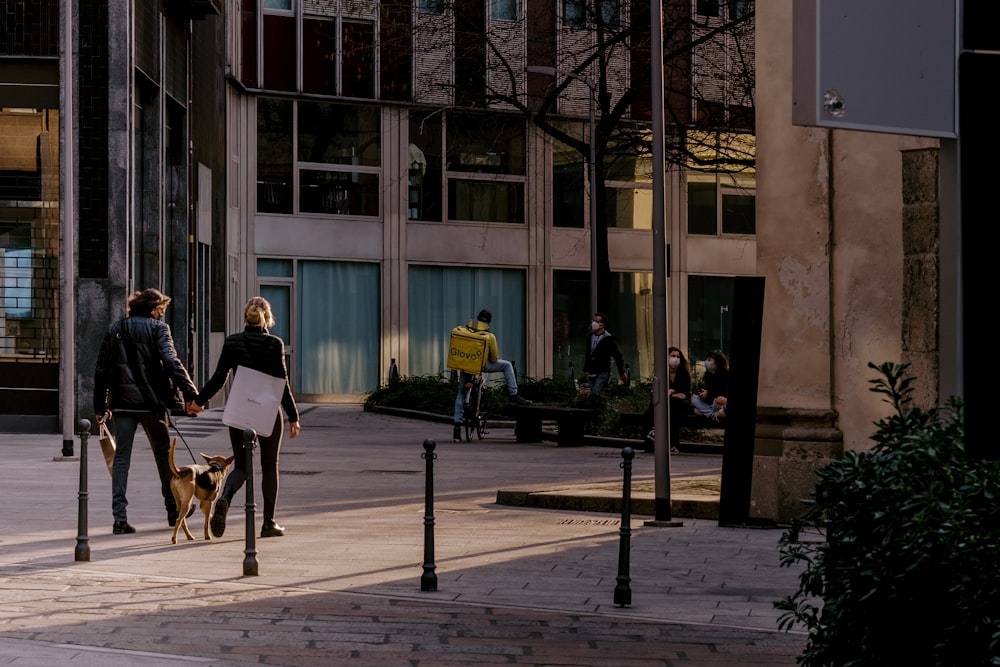 2 women sitting on bench near building during daytime