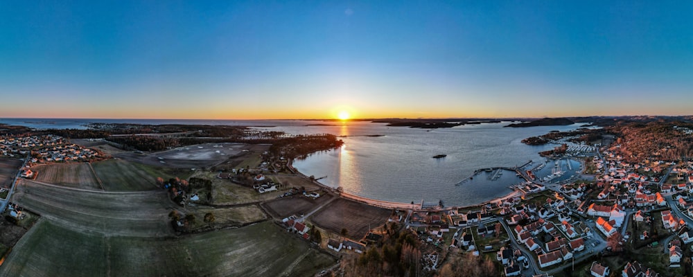 aerial view of city near body of water during sunset