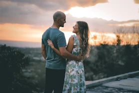 man and woman standing on the road during sunset
