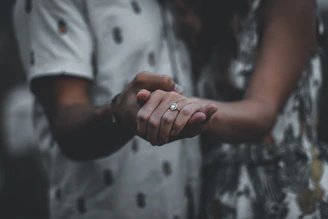 A cinematic shot of a couple holding hands with soft focus and rich colors.