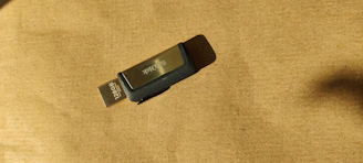 128GB USB 3.0 flash drive resting on a tech-themed dark surface with subtle blue accents.