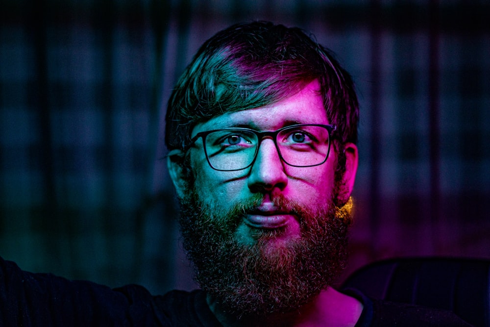 man in black framed eyeglasses and black sweater