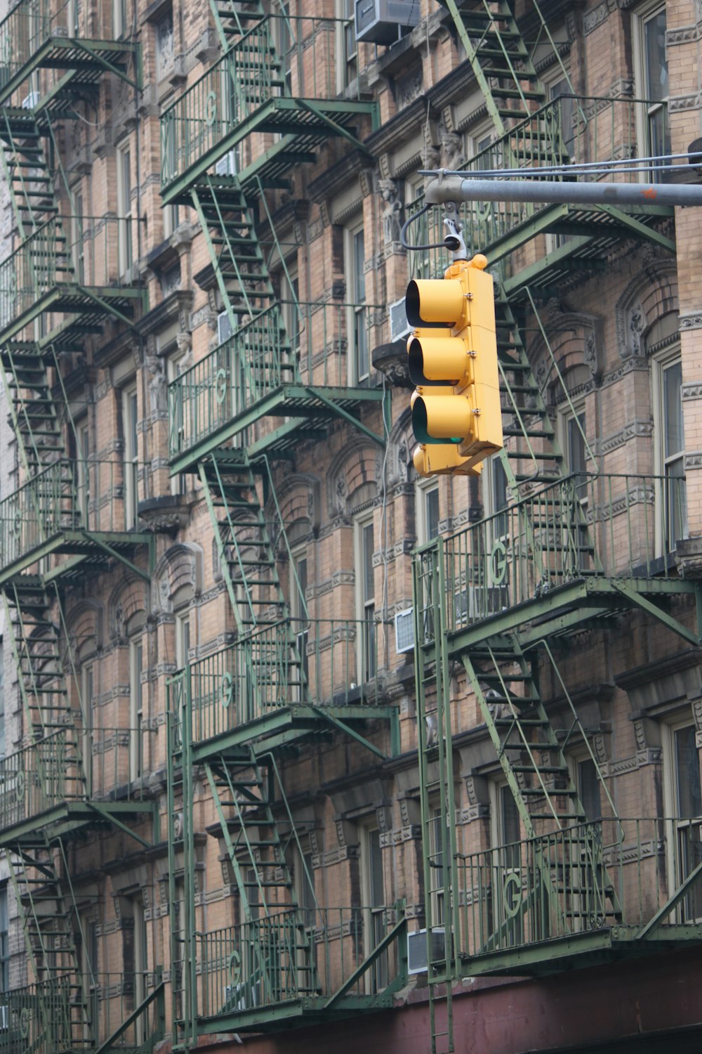 Gelbe Ampel vor grauem Betongebäude