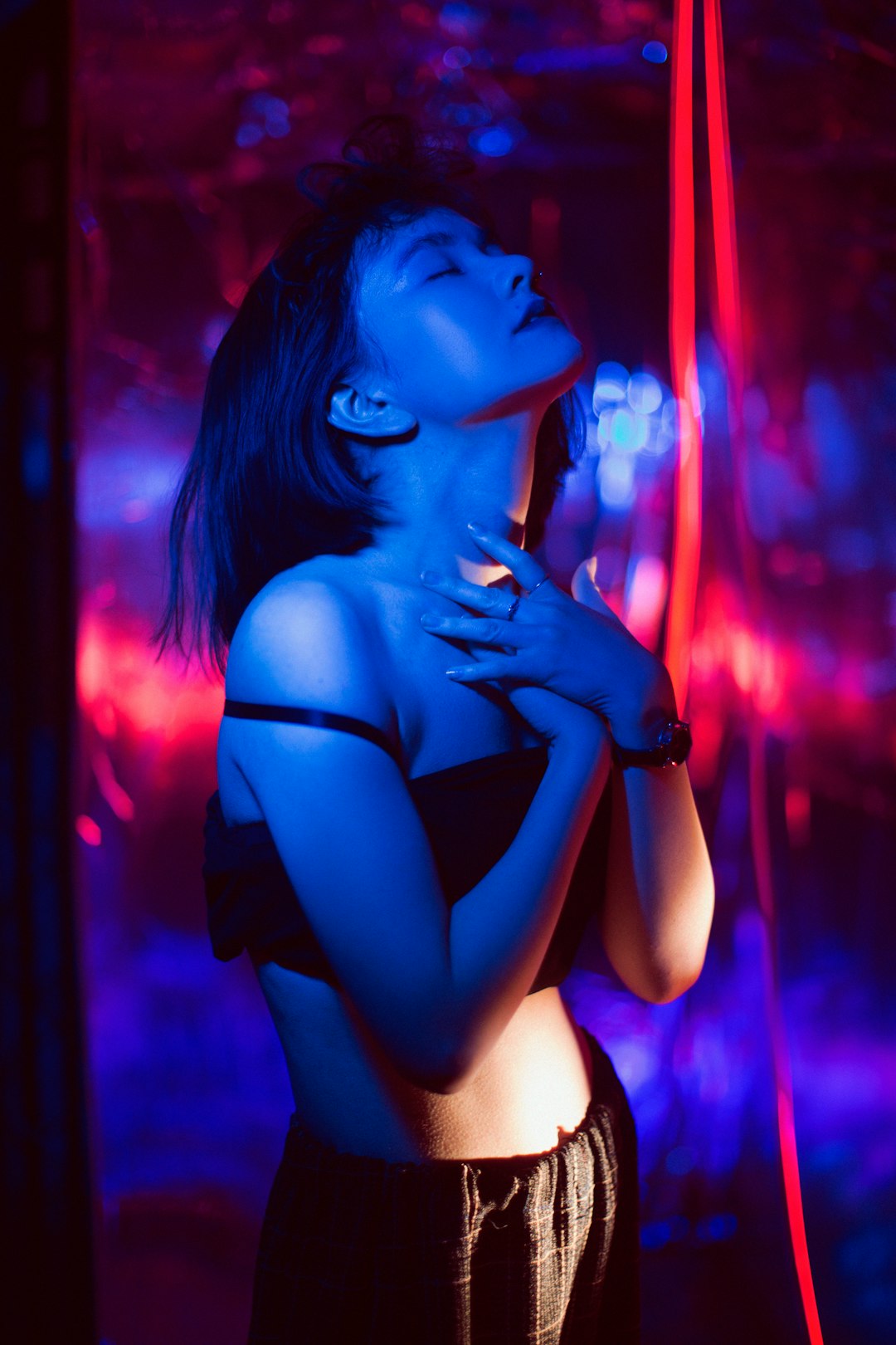 woman in black brassiere with blue and pink lights