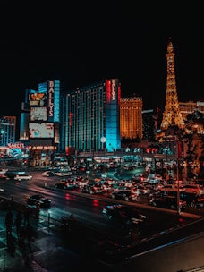 cars on road near high rise buildings during night time