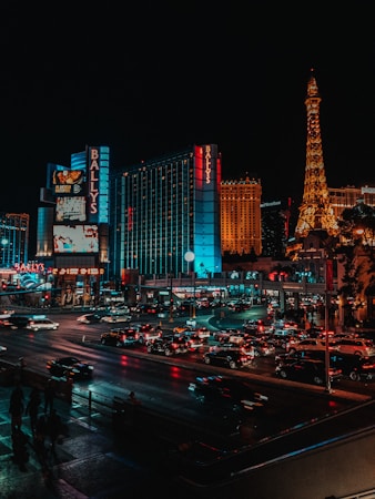 Cars driving past high rise hotel towers in downtown Las Vegas after dark