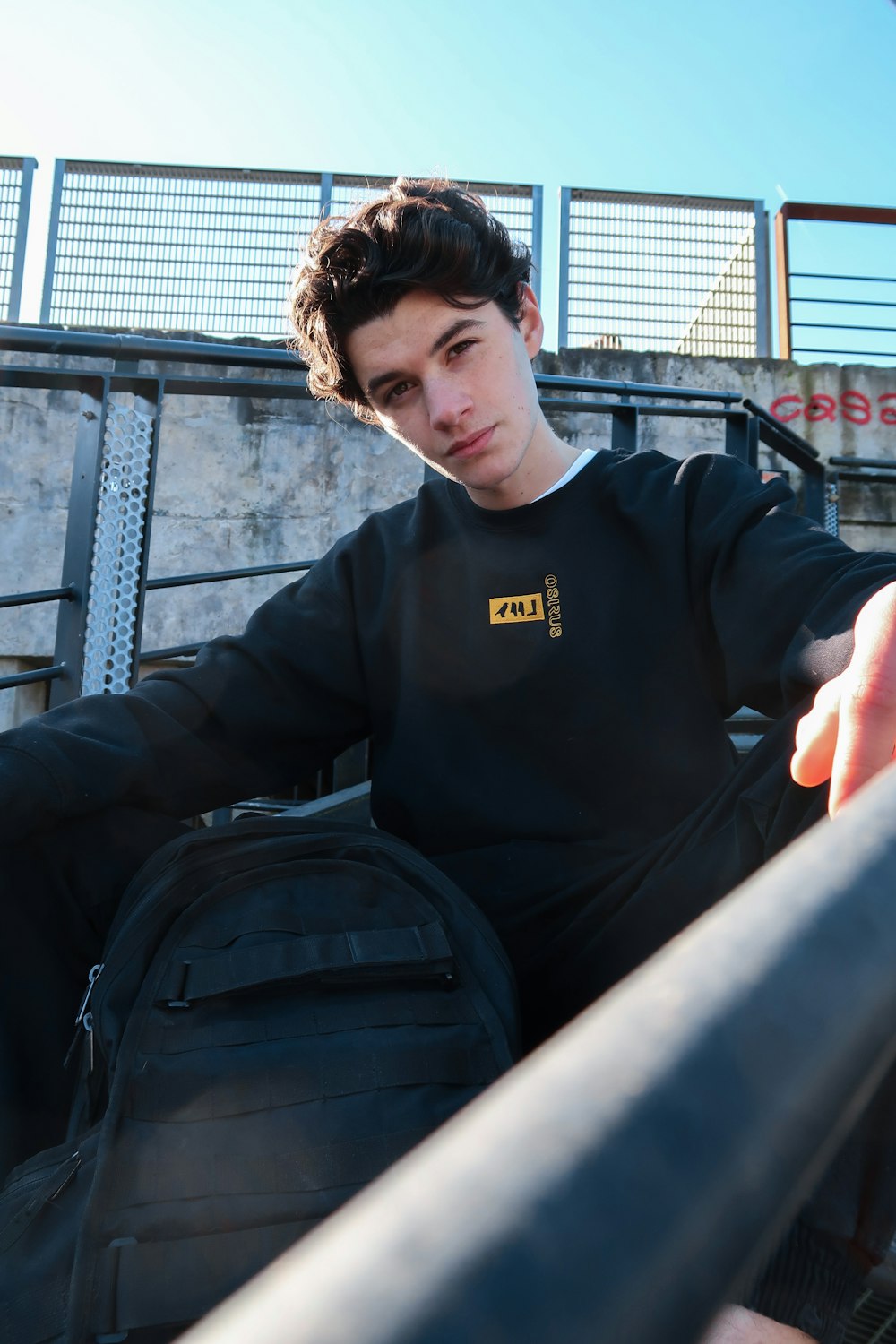 man in black sweater sitting on black chair