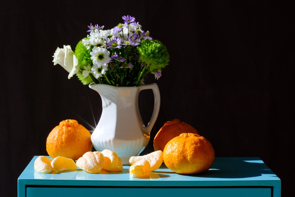 white and purple flower bouquet in white ceramic vase