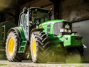 green and yellow tractor in garage
