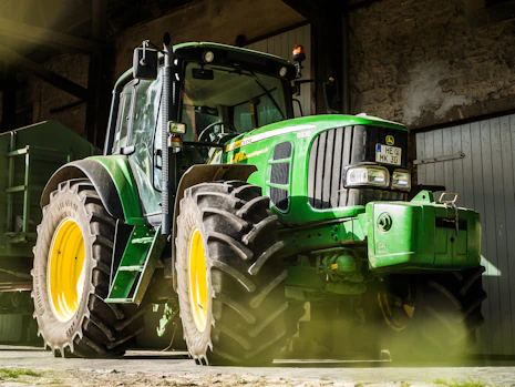 green and yellow tractor in garage