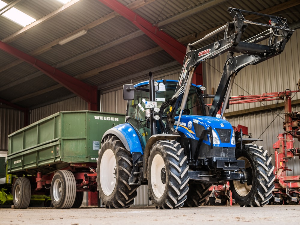 blue and black tractor near green trailer