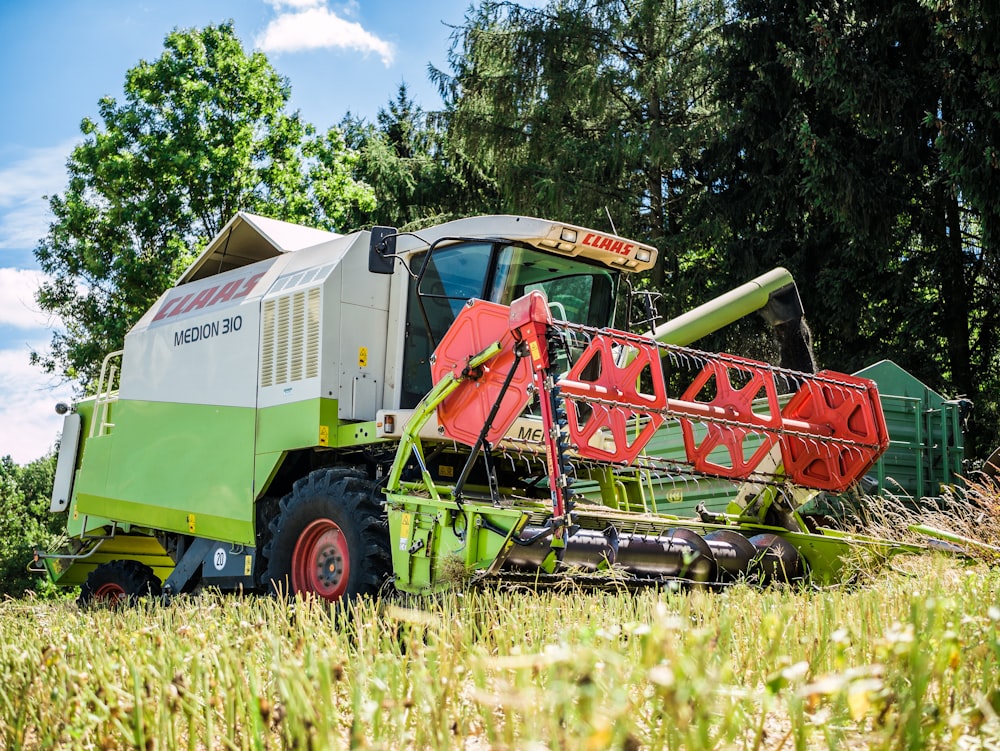 Équipement lourd rouge et jaune sur un terrain d’herbe verte pendant la journée